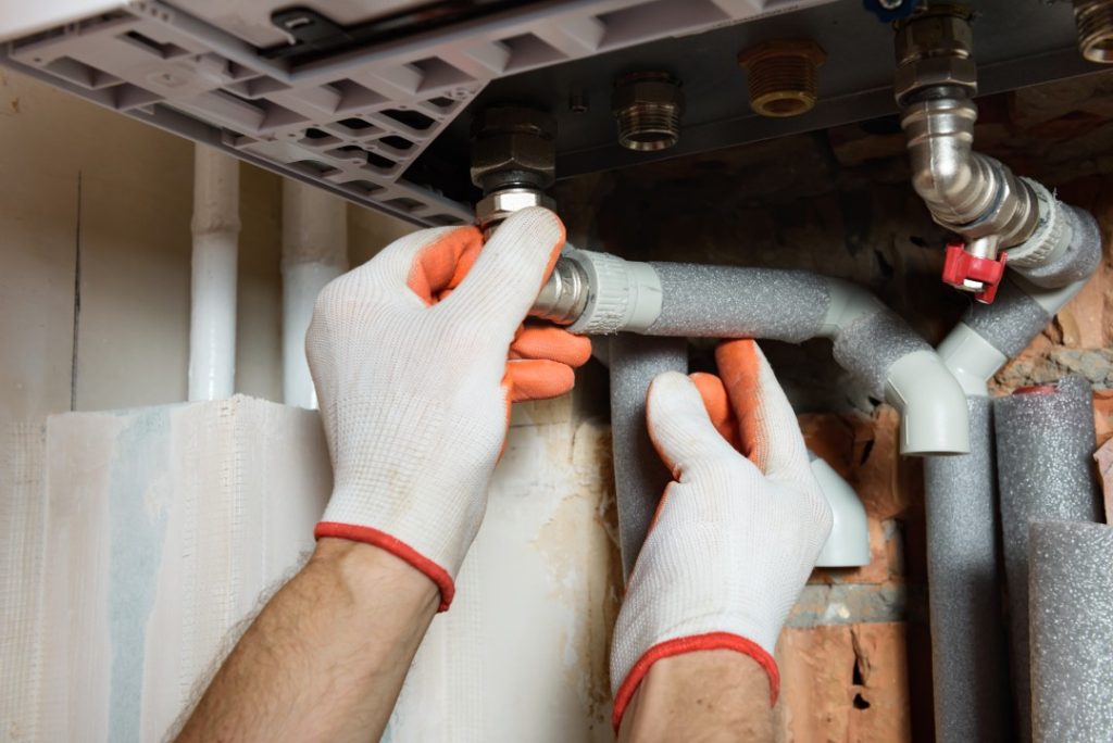 The Worker Is Installing The Gas Boiler Pipes.
