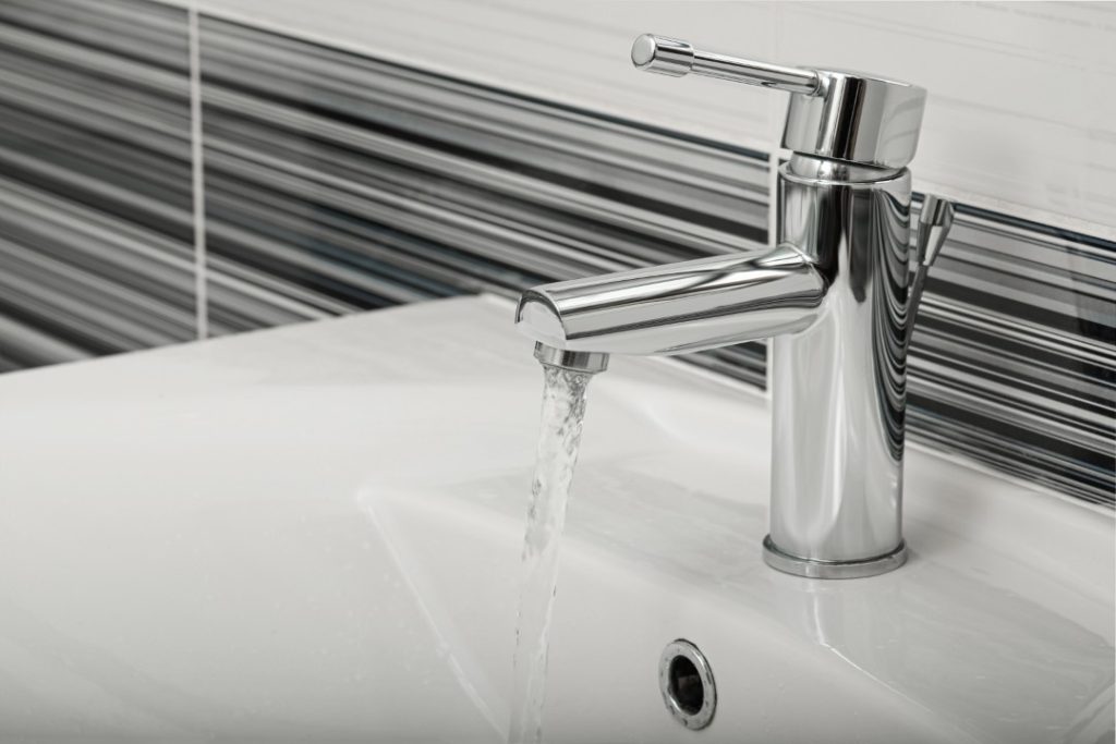 Stream Of Water Flowing From Tap In Bathroom