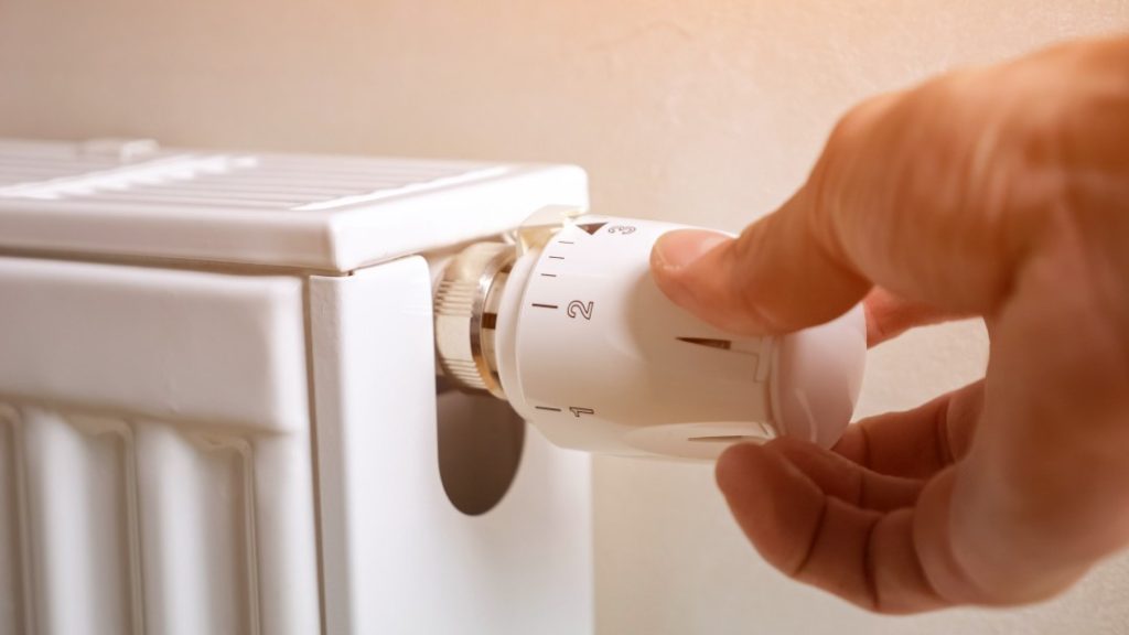 Man Hand Regulates Temperature On Radiator In Premise